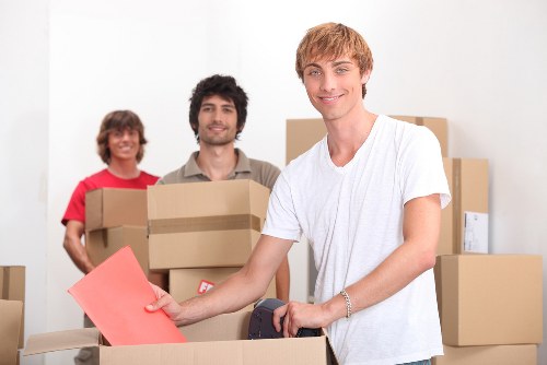 Team carrying a wardrobe through a narrow stairwell during furniture pick-up